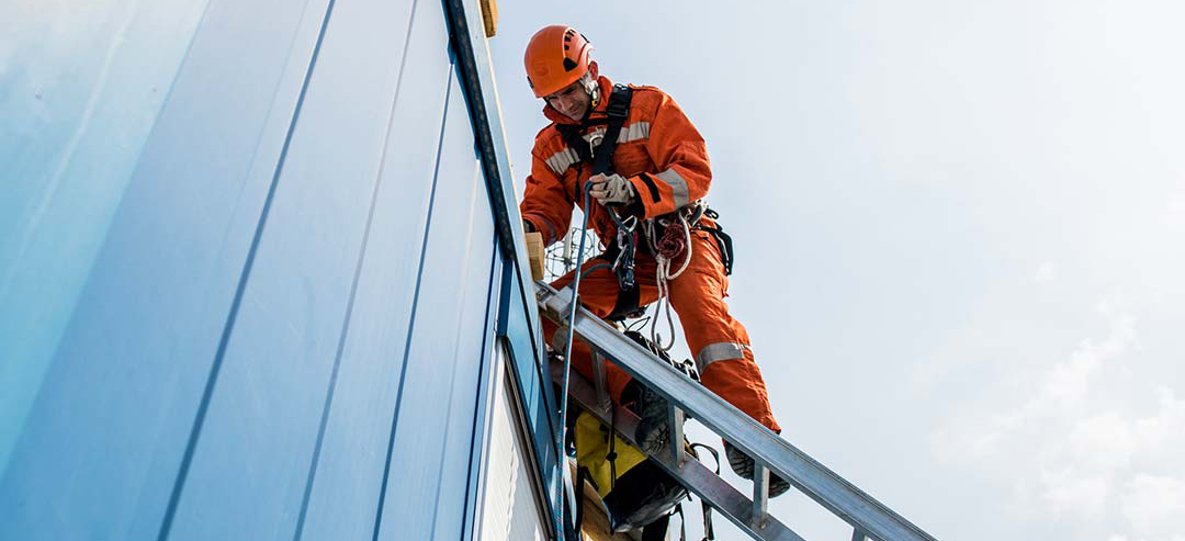 A worker scaling a building to wiring it