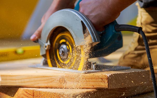 A carpenter cutting wood with circular saw