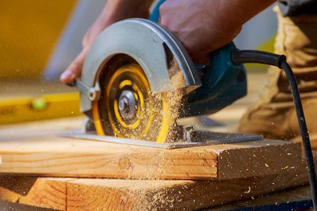 A person using a circular saw cutting wood