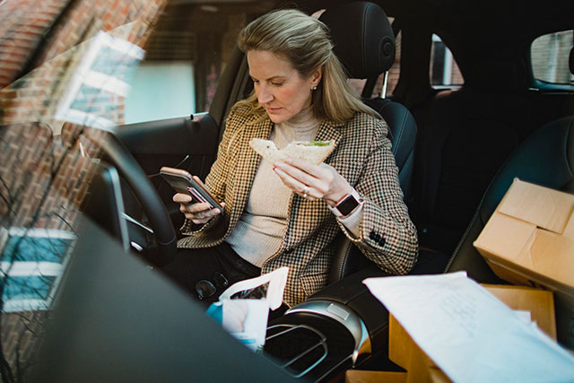 A business women eating lunch in her car and working.