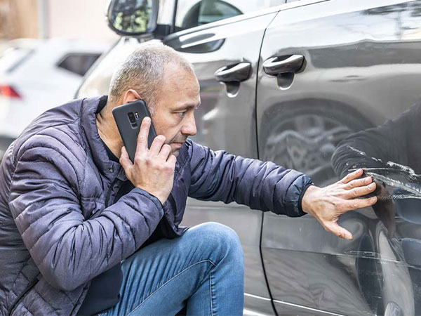 a person reviewing damage from a car accident