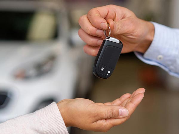 a person handing car keys to someone else