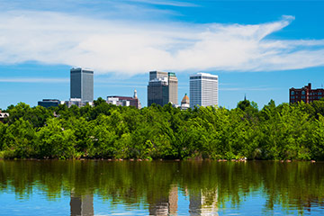 A view of buildings in Oklahoma from a park with a body of water