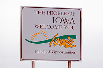 A white welcome to Iowa road sign