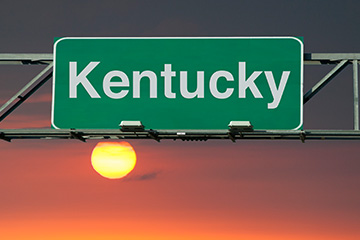 Green road sign that says Kentucky