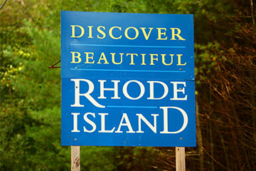 A blue state of Rhode Island road sign