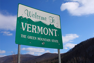 A green Welcome to Vermont road sign
